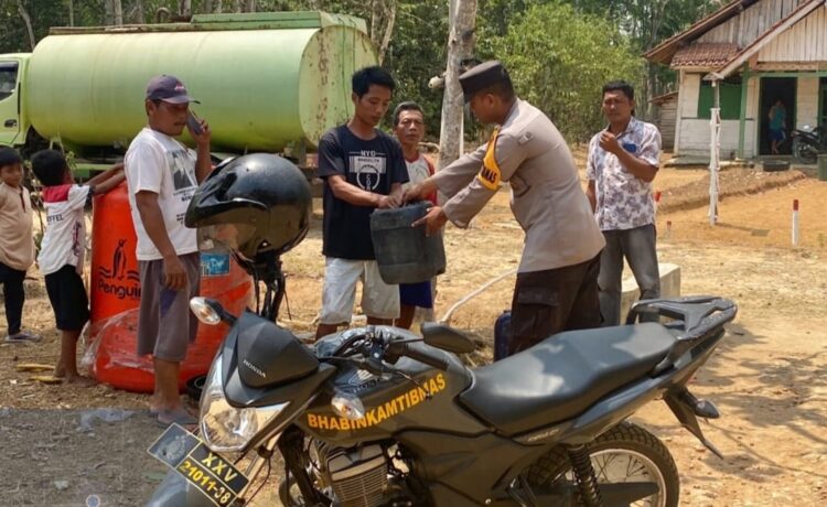 Kolaborasi Bhabinkamtibmas Polres Mesuji, BPBD dan TBL Suplai Air Bersih di Simpang Pematang